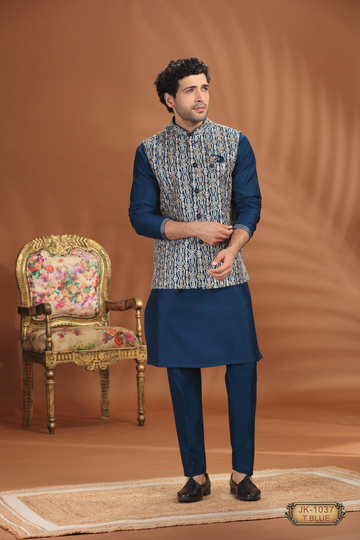 Man wearing blue kurta pajama with embroidered jacket.